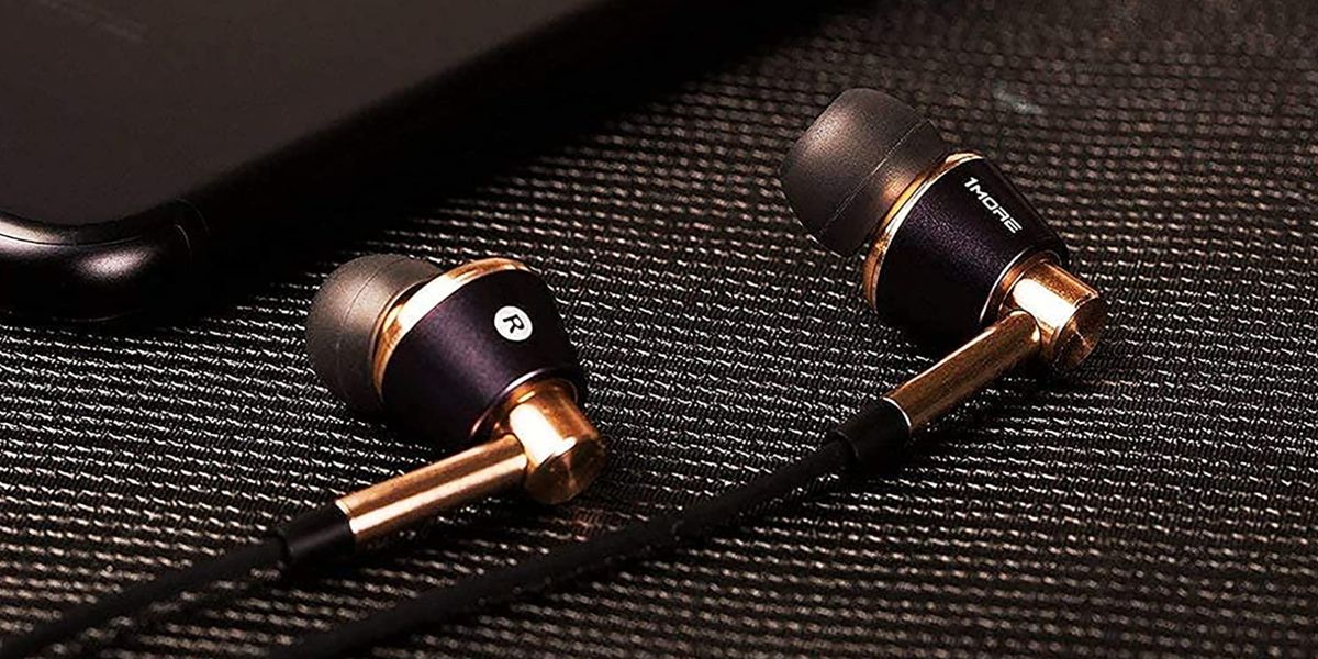 A pair of gold and black wired headphones lie side by side