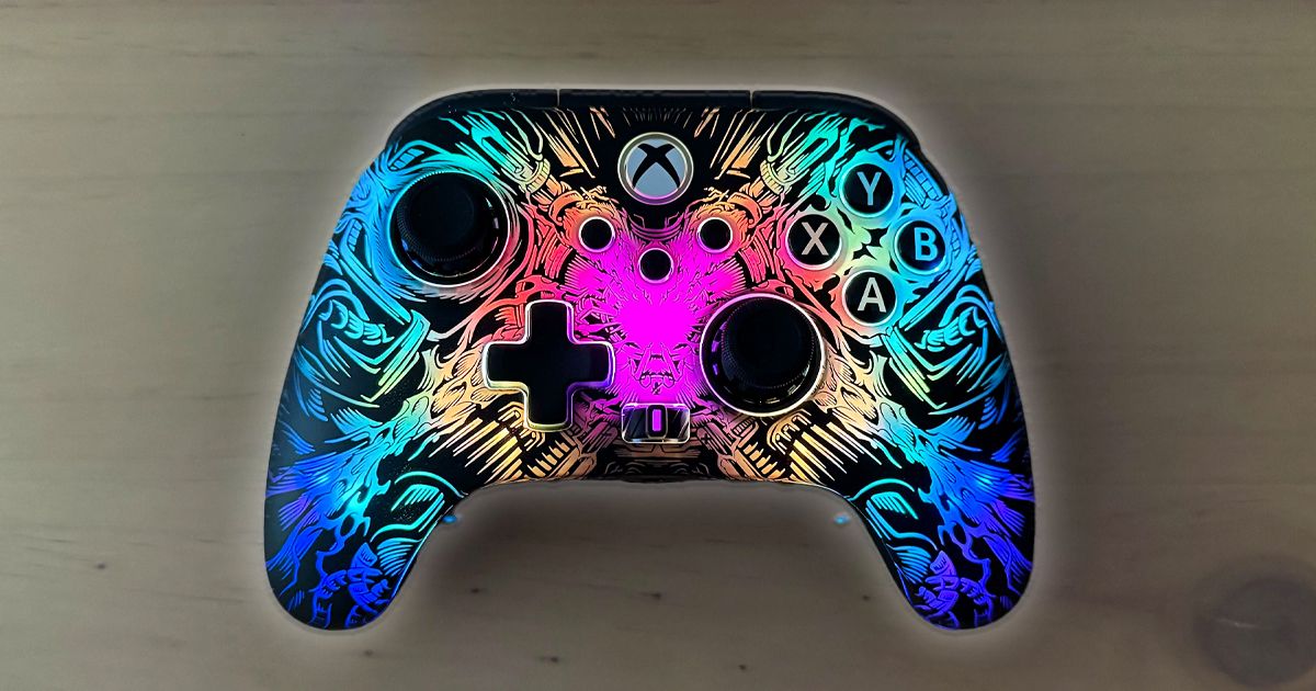 A black Xbox-style controller with multicolored Lumectra lighting on the front plate in a "ghost" pattern.