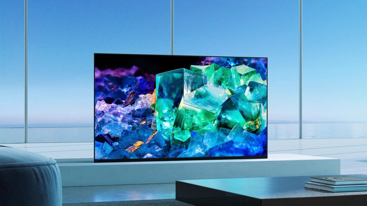 Image of a flatscreen OLED TV with crystals on the display, and the TV in front of a blue background.